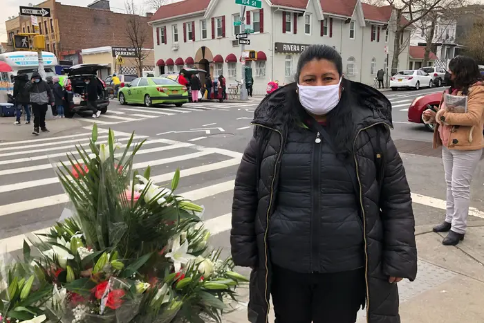 Corona resident Delphina Olvera selling flowers outside Our Lady of Sorrows Church on Easter Sunday. She said several church members died from COVID.